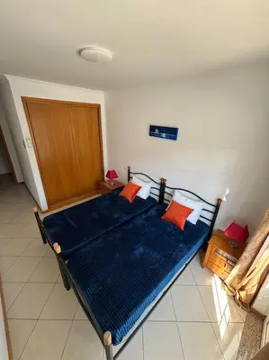 a bedroom with a bed with blue sheets and orange pillows at Apartment Blue Sun in Albufeira