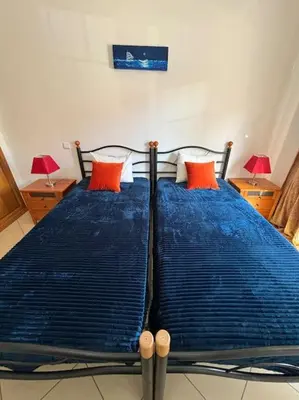 a bedroom with a blue bed with two red pillows at Apartment Blue Sun in Albufeira