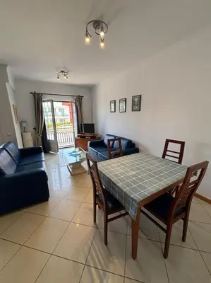 a living room with a table and chairs and a couch at Apartment Blue Sun in Albufeira