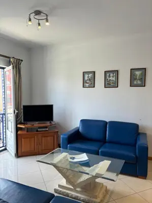 a living room with a blue couch and a tv at Apartment Blue Sun in Albufeira
