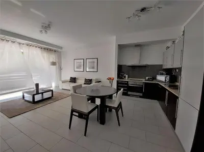 a kitchen and living room with a table and chairs at Al Baltum in Albufeira