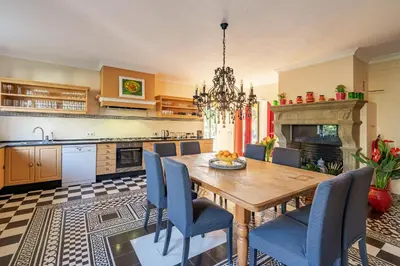 a kitchen with a wooden table and blue chairs at TheBougainVilla our Oceanview Villa in the Hills in Boliqueime