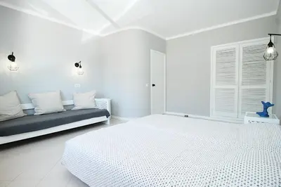 a white bedroom with two beds and a couch at BelaVista Tenis SweetHouse in Albufeira