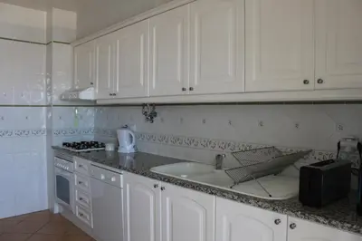 a kitchen with white cabinets and a sink at Beach&Golf Vilamoura Apartment in Vilamoura