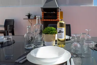 a table with a bottle of wine and a plate at Casa Amarela - Conforto e localização central! in Faro