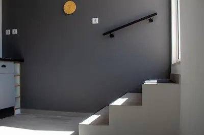 a room with stairs and a clock on the wall at Casa Amarela - Conforto e localização central! in Faro