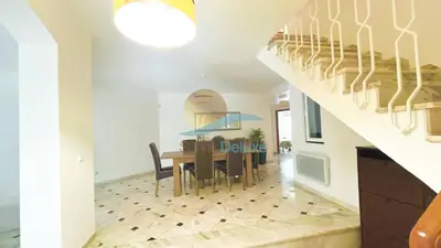 a dining room and kitchen with a table and a staircase at Villa GP by Sunny Deluxe in Albufeira