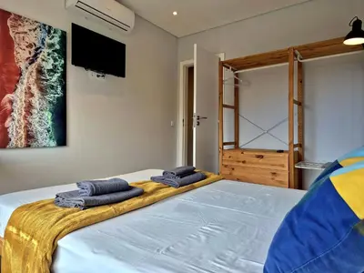 a bedroom with a large bed with towels on it at Campus 121 - Rooms in Faro