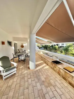 a living room with a wooden floor and a table and chairs at Casa Vale do Lobo in Vale do Lobo