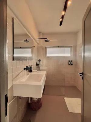 a white bathroom with a sink and a mirror at Casa Vale do Lobo in Vale do Lobo