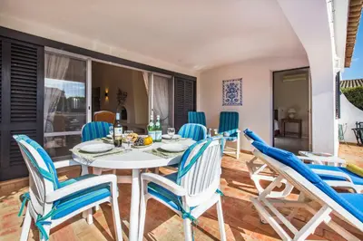 two blue chairs on a patio with a swimming pool at Mng Elliott55 in Vale do Lobo