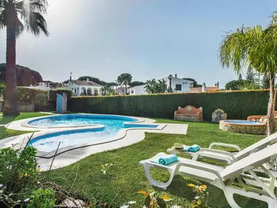 a swimming pool in a yard with a white bench at Villa Vera VIP Properties by Interhome in Vilamoura