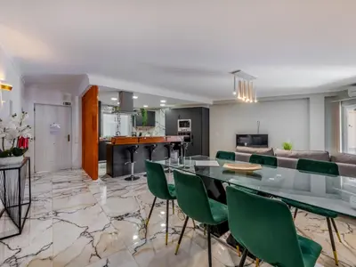 an open living room and kitchen with a table and green chairs at Apartment T2 Cassias VIP Properties by Interhome in Vilamoura