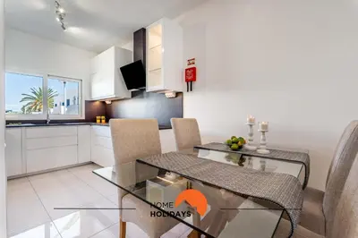 a kitchen and dining room with a glass table and chairs at #220 Windmill Hill by Home Holidays in Albufeira
