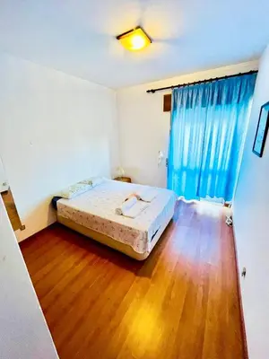 a bedroom with a bed and a wooden floor at Apartamento Faro - T3 in Faro