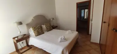 a bedroom with a bed with white sheets and pillows at Casa Golfinho, Albufeira in Albufeira