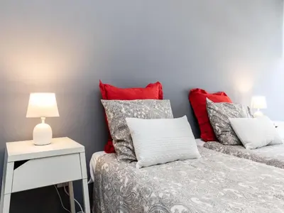 a bedroom with two beds and a table with lamps at Akisol Faro Sunny in Faro