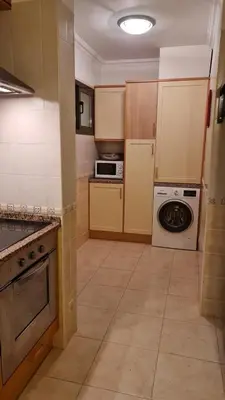 a kitchen with a stove and a washer and dryer at FERIAS NA PRAIA in Albufeira