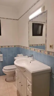 a bathroom with a sink and a toilet and a mirror at FERIAS NA PRAIA in Albufeira