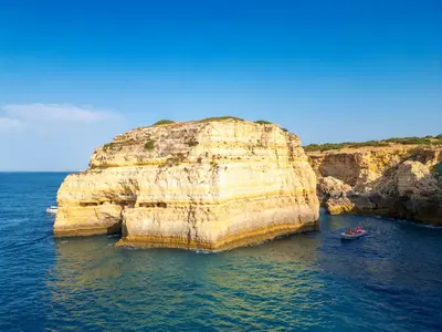 a large rock formation in the water with two boats at Villa Dolce Vita by Algarve Vacation in Albufeira