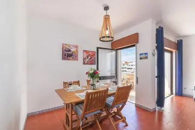 a dining room with a table and chairs at Quarteira Mar à Vista T1 in Quarteira