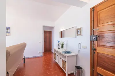 a bathroom with a sink and a wooden door at Quarteira Mar à Vista T1 in Quarteira