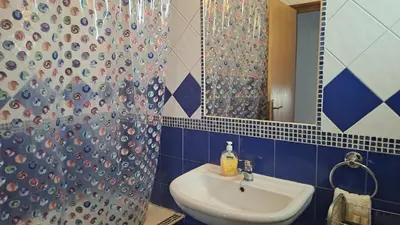 a bathroom with a sink and a shower with a mirror at Albufeira Seaview 4 Beach HOUSE in Albufeira