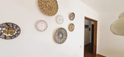 a wall with plates hanging on a wall at Beach House Vidinha in Albufeira