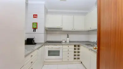 a kitchen with white cabinets and a stove top oven at Al Charb TopFloor sea view, ar con, pool - CleverDetails in Vilamoura