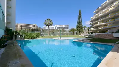 a large blue swimming pool next to a building at Al Charb TopFloor sea view, ar con, pool - CleverDetails in Vilamoura