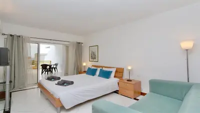 a bedroom with a bed and a couch and a tv at Al Charb TopFloor sea view, ar con, pool - CleverDetails in Vilamoura