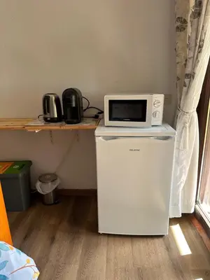 a microwave sitting on top of a refrigerator at Casa Amarela in Faro