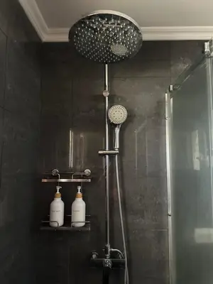 a shower in a black bathroom with a shower head at Casa Amarela in Faro