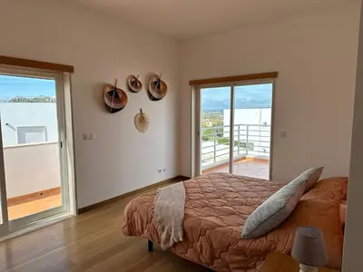 a bedroom with a bed and a view of the ocean at Vila Nalia in Albufeira