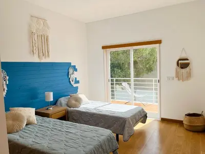 a bedroom with two beds and a blue headboard at Vila Nalia in Albufeira
