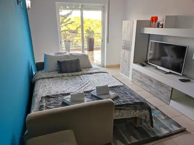a living room with a bed and a tv at Lovely 2 Bedroom S Jose Apartment in Albufeira