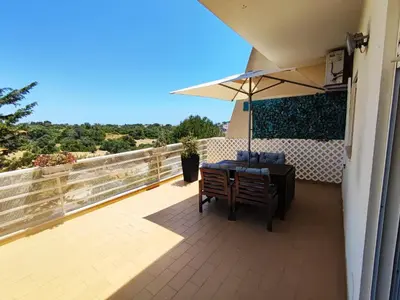 a patio with a table and an umbrella at Lovely 2 Bedroom S Jose Apartment in Albufeira