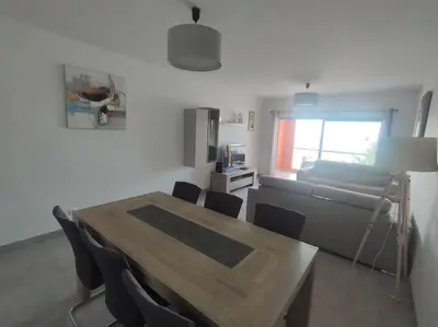 a living room with a table and chairs and a couch at Luxury apartment in Vitismar condo view sea & pool in Galé