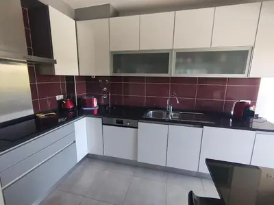 a kitchen with white cabinets and a sink at Luxury apartment in Vitismar condo view sea & pool in Galé