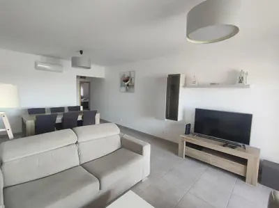 a living room with a couch and a flat screen tv at Luxury apartment in Vitismar condo view sea & pool in Galé