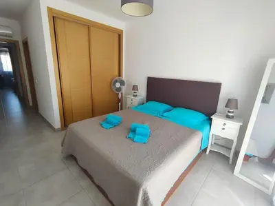 a bedroom with a bed with blue pillows on it at Luxury apartment in Vitismar condo view sea & pool in Galé