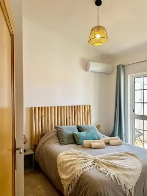 a bedroom with a large bed with blue pillows at Casa Esperança in Albufeira