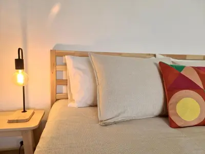 a bed with white pillows and a table with a lamp at Fig Villa- CleverDetails, Sleep 8, Pool, Children Playground, Ténis court in Vilamoura