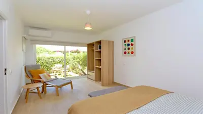 a bedroom with a bed and a chair and a table at Fig Villa- CleverDetails, Sleep 8, Pool, Children Playground, Ténis court in Vilamoura