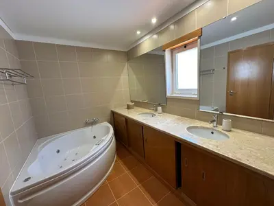 a bathroom with two sinks and a bath tub at Vila Elvia in Albufeira