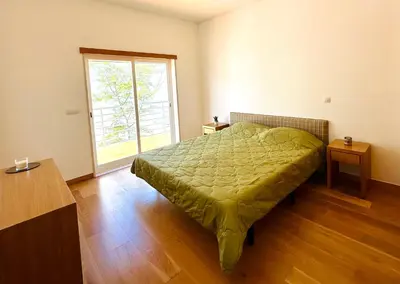 a bedroom with a green bed and a window at Vila Elvia in Albufeira