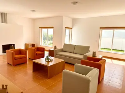 a living room with couches and chairs and a table at Vila Elvia in Albufeira