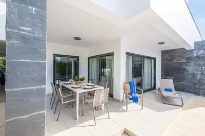 a dining room with a table and chairs at Villas Novochoro - Small Garden by DreamvillasAlbufeira in Albufeira