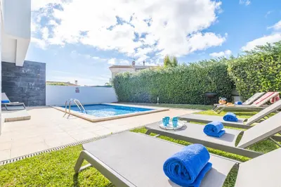 a backyard with a swimming pool and patio furniture at Villas Novochoro - Small Garden by DreamvillasAlbufeira in Albufeira