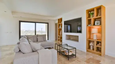 a living room with a couch and a tv at Brand New Waterfront Villa with pool in Faro